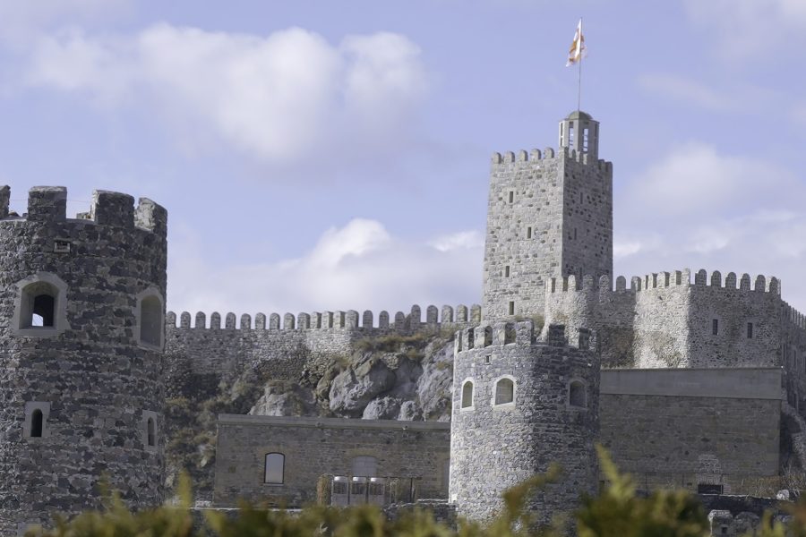 Ancient stone fortress with towers. Action. Fabulous view of stone fortress with towers in medieval style. Beautiful stone fortress with strange medieval architecture in summer
