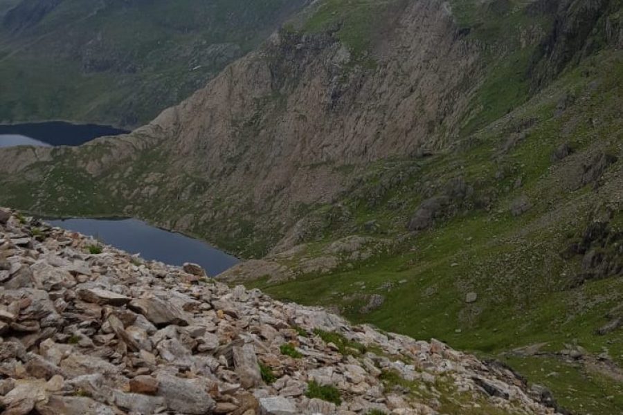 A scenic view of Snowdon’s trails and surrounding mountains in Snowdonia National Park, Wales, showcasing natural beauty and rugged terrain.
